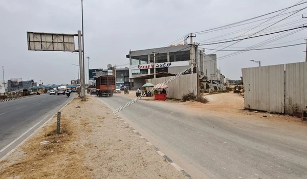 Active daytime traffic including scooters traveling on the well-paved main road bordering the Sobha One Residences property