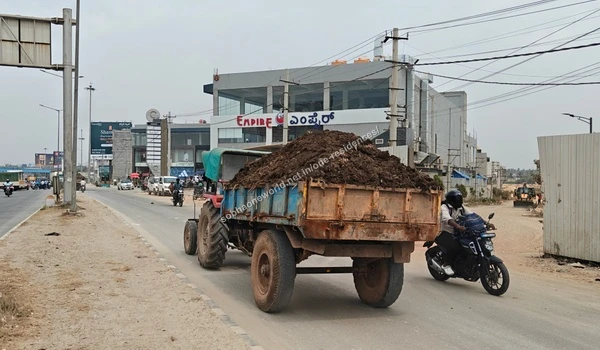 A wide daytime view of the main road showcasing the Empire restaurant building right next to the entrance of Sobha One Residences