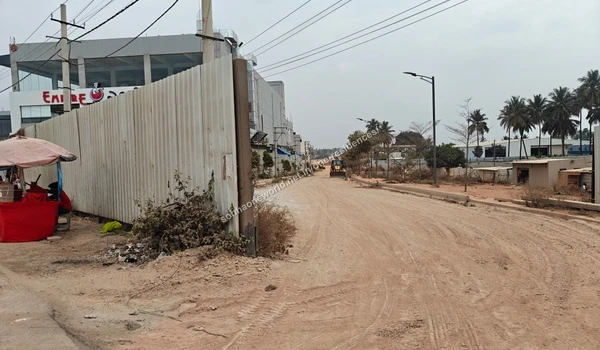 Local commuters carrying goods on a motorcycle along the highway directly outside the perimeter of Sobha One Residences