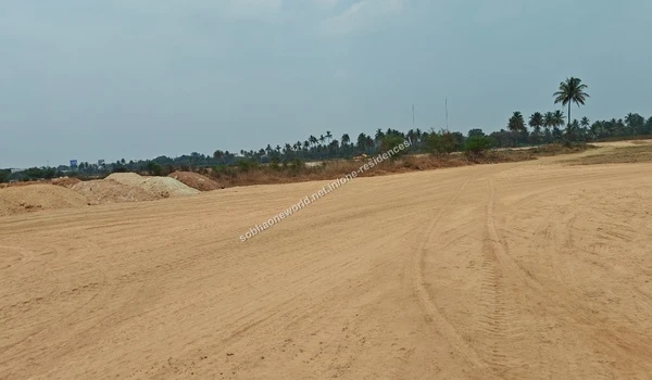 Large pile of reddish excavated earth surrounded by natural greenery at the Sobha One Residences plot