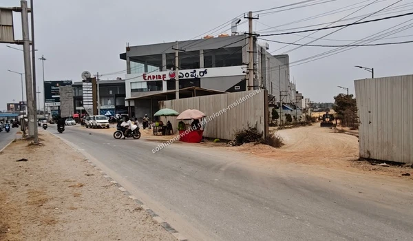 Pedestrians and vendors situated along the street view near the entrance of Sobha One Residences
