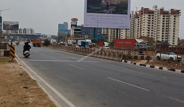 Wide view of the main highway displaying the prominent Sobha One World billboard and the surrounding urban infrastructure
