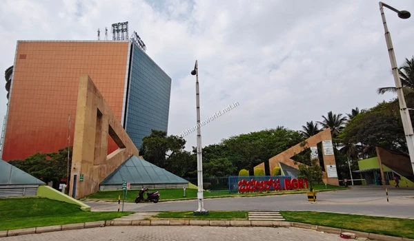 Wide exterior view of the sprawling corporate campus featuring modern glass buildings and massive entry gates near Sobha One World