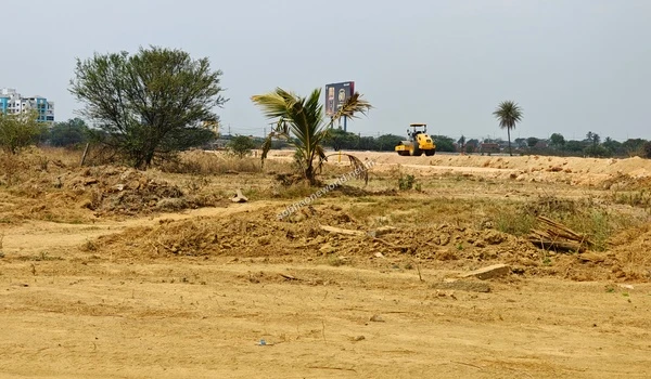 Uneven, recently excavated earth in the foreground of the Sobha One World location with active site leveling happening in the distance.