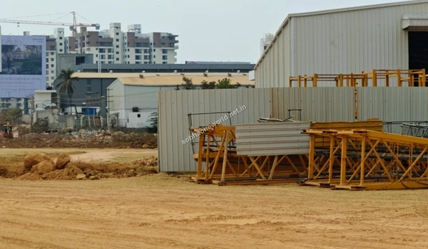 Detailed view of the primary construction staging grounds at Sobha One World featuring large sheds and metal framework structures.
