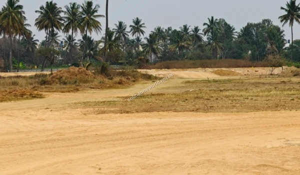 A freshly graded dirt road passing through the Sobha One World location in the distance, highlighting the active terrain modification.