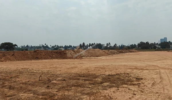 Panoramic view across the vast, leveled construction grounds of Sobha One World, showing extensive soil movement activities and distant tree lines.