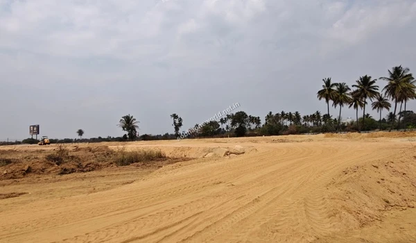 Distinct curved tire tracks and graded paths indicating future internal roadways being marked out on the sandy soil at the Sobha One World development area.