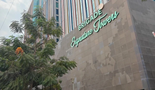 Sweeping view of the grand business park entryway featuring geometric glass designs and vast road connectivity near Sobha One World