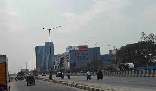 Wide view of the multilane highway leading towards the Sobha One World project showcasing nearby commercial infrastructure
