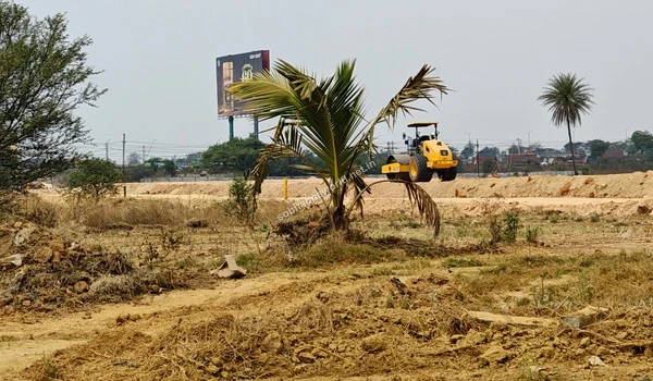 A leveled dirt boundary road highlighting the extensive ground preparation across the Sobha One World site.