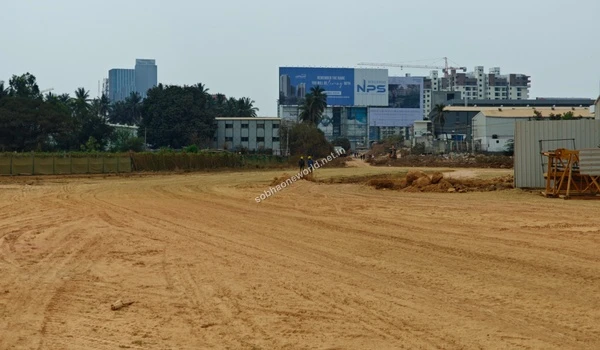 Sweeping view of the expansive cleared path at Sobha One World leading towards the central operations area and modern high-rise apartments.