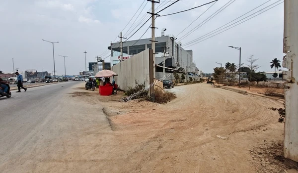 The secure site enclosure and fencing running parallel to the active street near the Sobha One World construction zone.