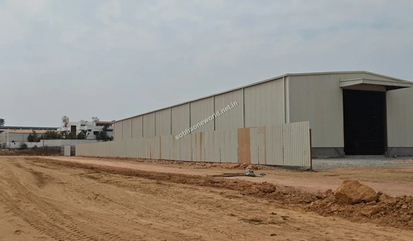 Exterior view of the white temporary site facility and boundary wall at the expansive Sobha One World project location