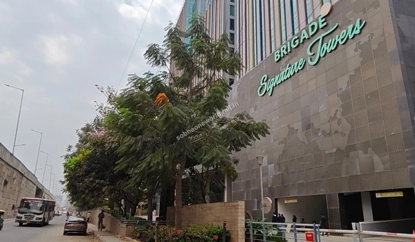 Impressive corporate facade with bright red signage representing the thriving business ecosystem neighboring Sobha One World