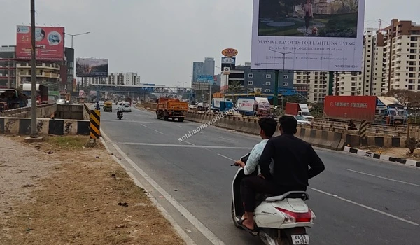 Broad urban roadway directing traffic towards KR Puram located exactly at the Sobha One World entrance area
