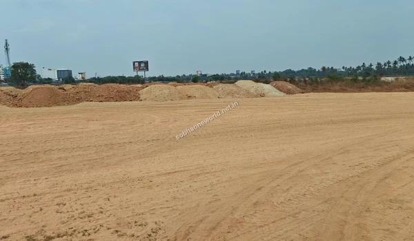 A continuous long boundary of excavated earth separates the cleared sandy tract across the Sobha One World property perimeter.