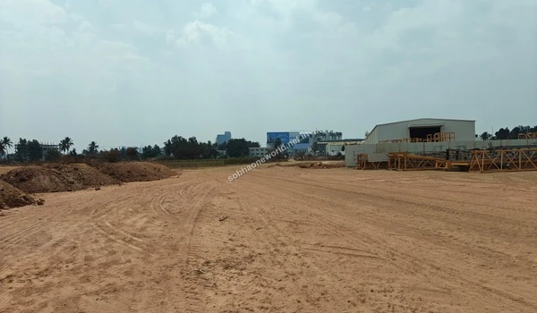 Wide expanse of the leveled staging area at Sobha One World with construction frameworks resting on the right side.